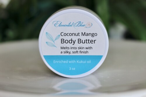 Jar of Elemental Blue Coconut Mango Body Butter enriched with kukui oil, a moisturizing body butter that melts into skin with a silky, soft finish.